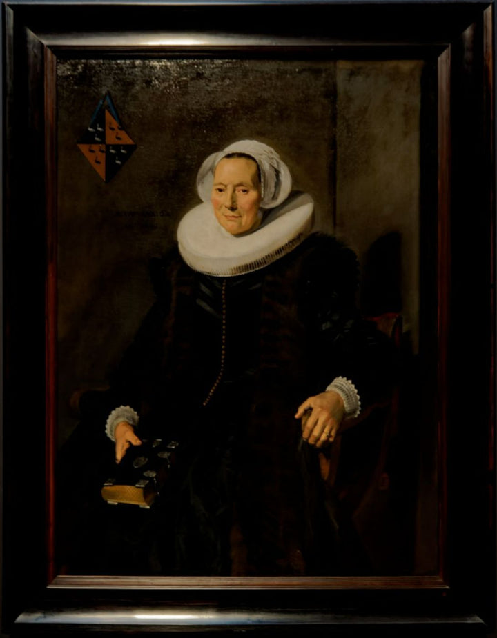 Portrait of a sitting, sixty year old woman with book in his right hand